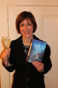 Jane with book and glass of champagne