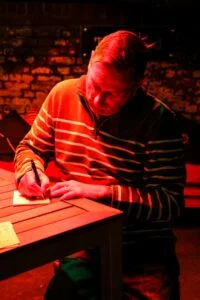 Photo of Chris Casburn signing a book