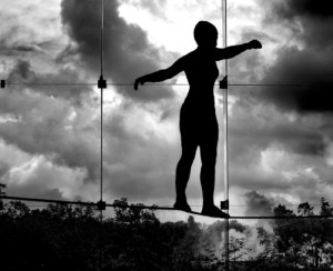 Image of a tightrope walker carefully balancing on a high wire
