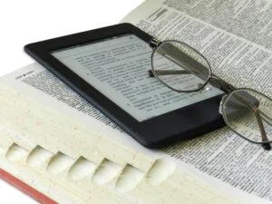 photo of ereader, glasses and dictionary