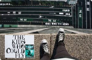 View from top of a high building with a book next to a pair of feet