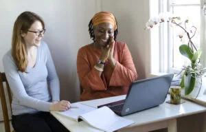 Two authors chatting in front of a laptop