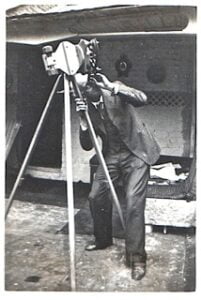 black and white historic photo of man with early telescope