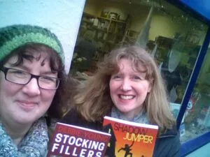 Debbie Young and Julia Forster holding books outside a shop