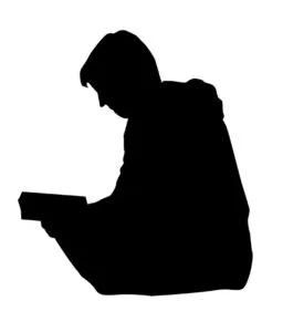 SIlhouette of a man reading a book