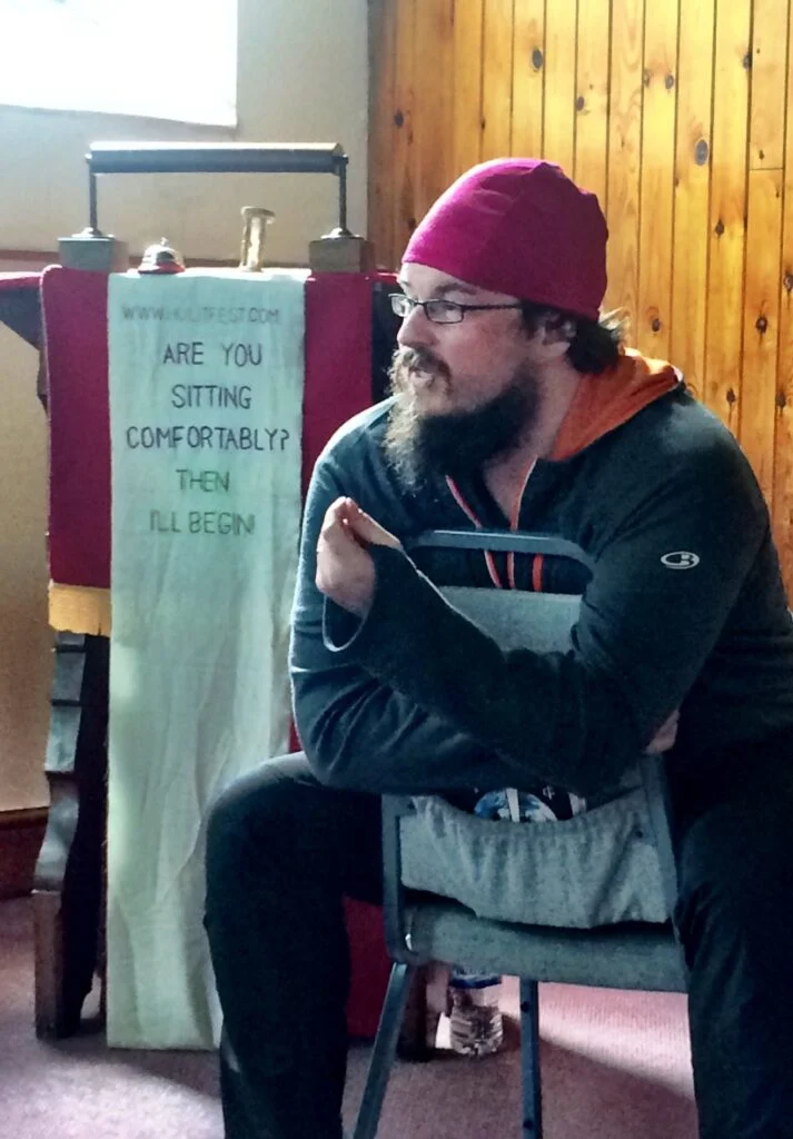Photo of Dan in front of banner in chapel