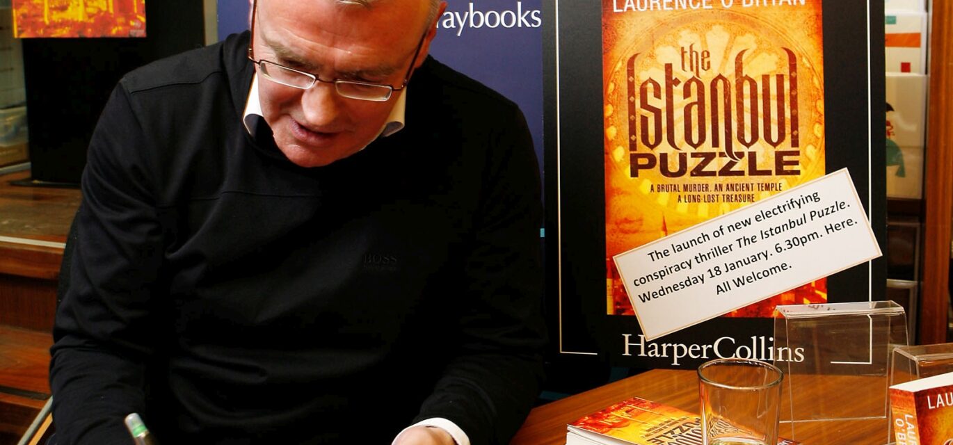 Photo of Laurence O'Bryan signing a book