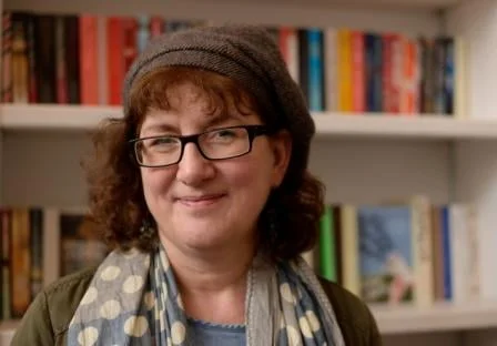 Headshot Of Debbie Young In Front Of Bookshelves