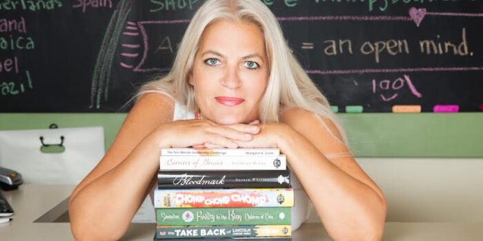 Headshot of Patti with a pile of books