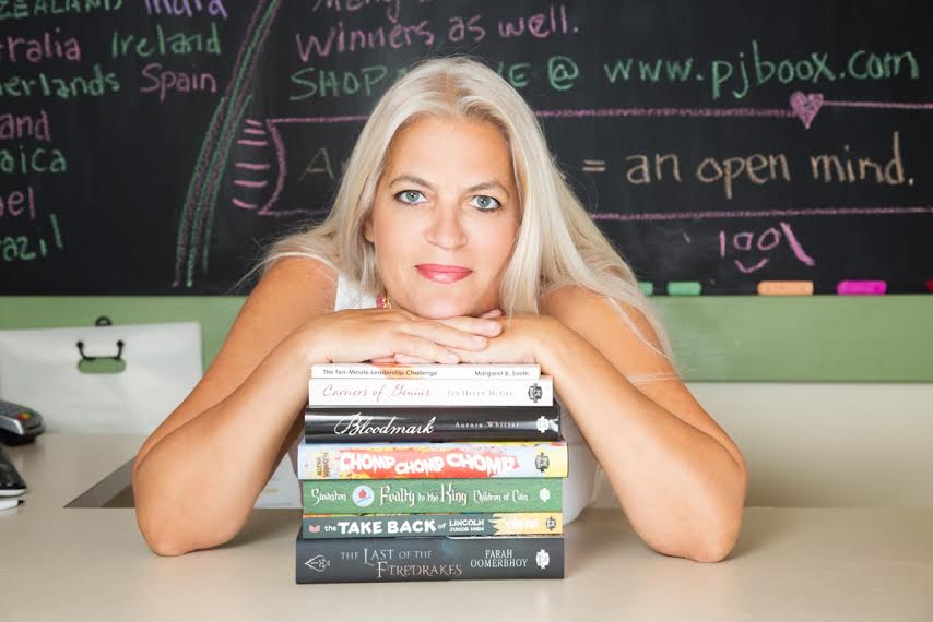 Headshot Of Patti With A Pile Of Books