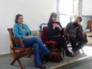 photo of three on chairs on small dais