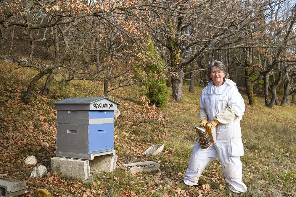 Photo of Jean Gill tending to her beehive