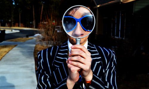 photo of person looking through magnifying glass