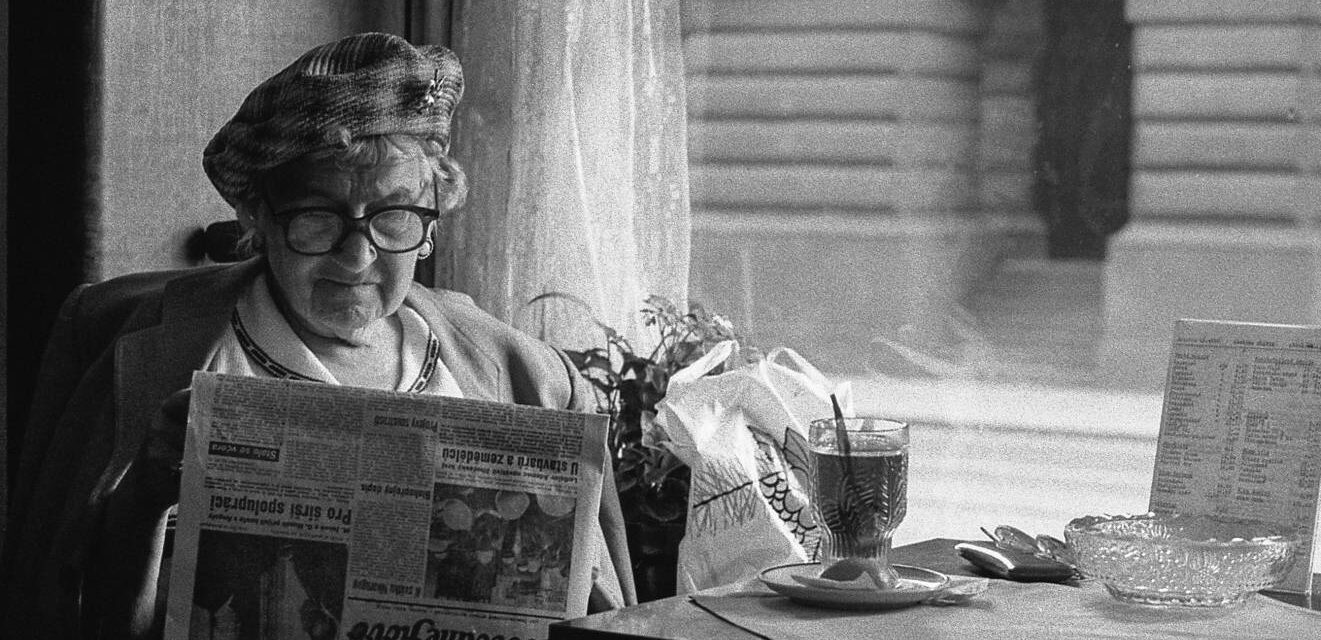 image of old lady reading a newspaper in a vintage photo