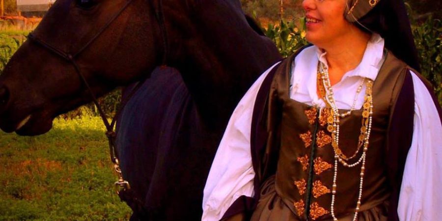 photo of Emily Cotton in medieval dress with horse