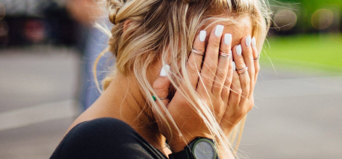 image of girl with hands over face in regret