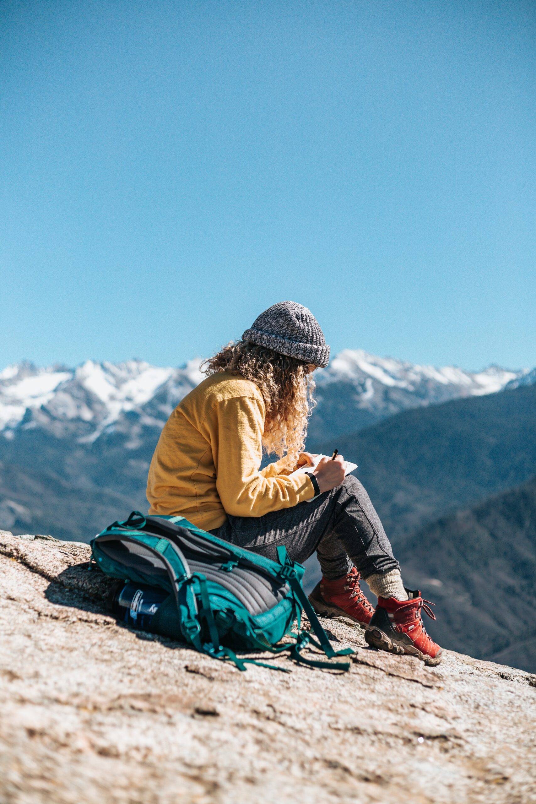 Girl Sitting Writing On Mountain