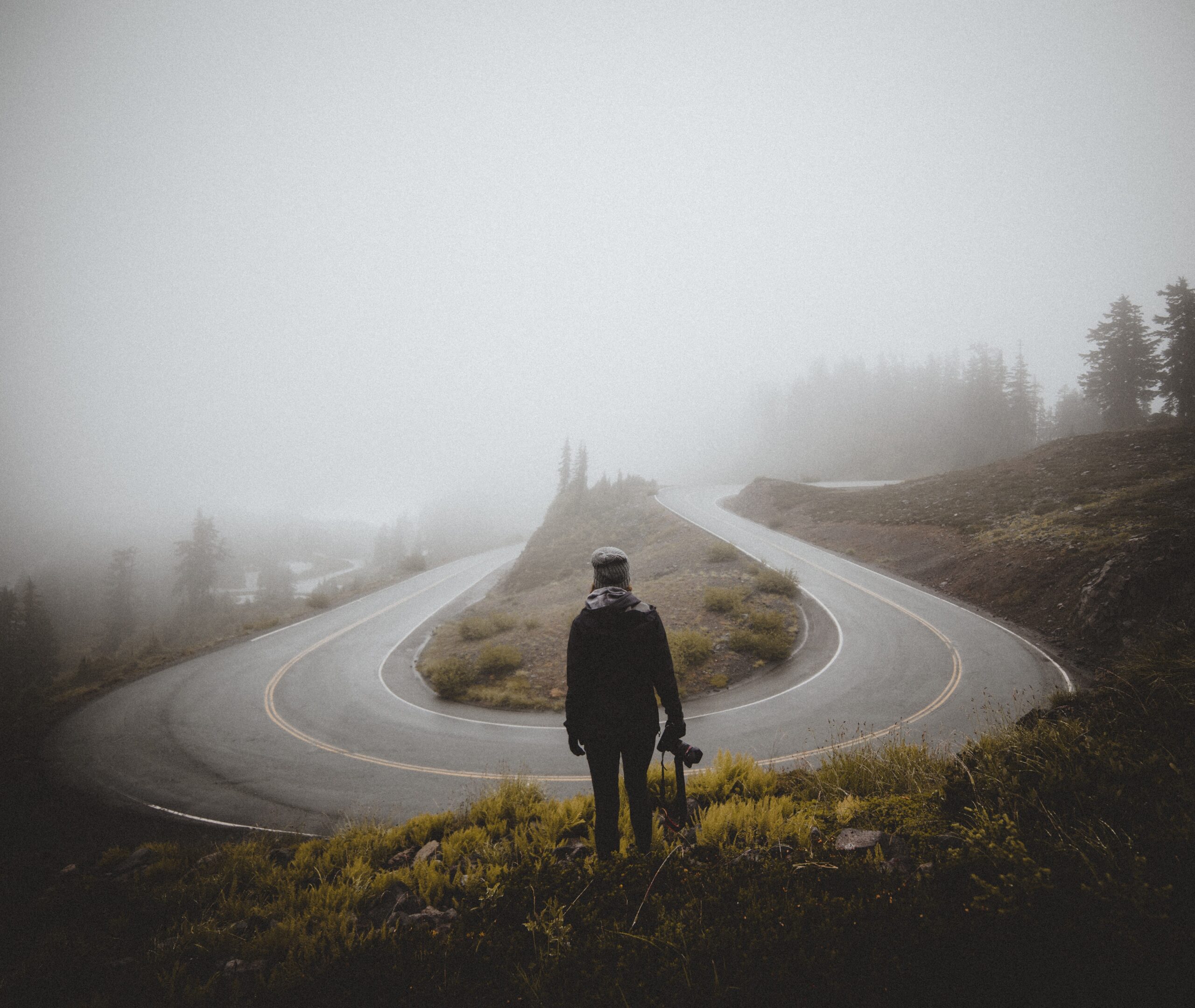 Photo Of U-bend In Road And Man Looking At It To Signify A Turning Point