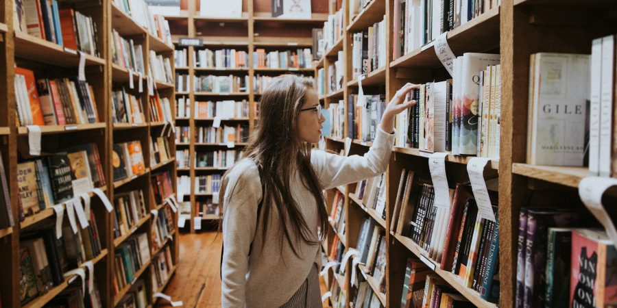 A Woman Browsing Shelves In A Bookstore