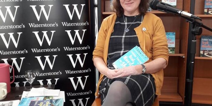 Debbie Young with her books in bookstore with Waterstones brand clearly visible