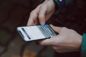 image of phone in someone's hands sending a text
