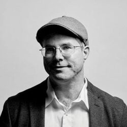 Man In Cap And Glasses, Wearing Blazer.