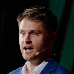 Man Speaking With Microphone On Stage.